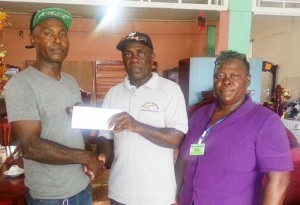 Mr. Carmichael (left) of the WBCA accepts one of the cheques from NPG Packaging supervisor Jacob Hikel. 