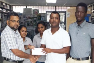 Waqar Sahid (left), Managing Director of A. Ally and Sons Showroom hands over a cheque to YWCC first division skipper Waheid Edwards. 