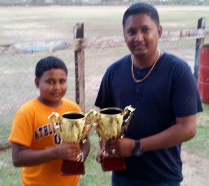 Young Simon Naidoo of RHTY&SC hands over trophies to Vicky Bharosay of YWCC. 