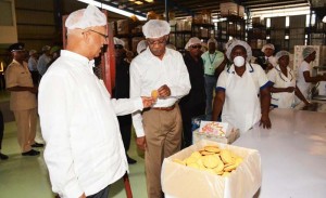 President David Granger examines a freshly-made Trisco biscuit, which is distributed at Nursery and Primary Schools countrywide.