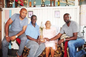 Organising secretary of the Georgetown Dominoes Association Mark Wiltshire (2nd left) and wife of the late Roy Davis, Lorna Davis display the first place trophy with members of the Providence team Randy Davis (left) and Sean Davis. 