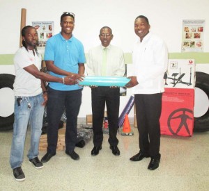  Cevons’ Logistics Coordinator Kwesi Boston hands over the items to GPHC Chief Executive Officer, Allan Johnson as Head of the Hospital Security, Mark Lewis and Maurice Archer, Research and Development Officer, Cevons look on.