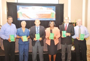 In photo from left, holding the STG are: Chief Medical Officer, Dr. Shamdeo Persaud; Supply Chain Management System Consultant, Dr. Claudette Harry; Public Health Minister, Dr. George Norton; Minister within the Ministry of Public Health, Dr. Karen Cummings; Acting USAID Mission Director, Mr. Edward Lawrence and Supply Chain Management System Country Director, Mr. Marvin Couldwell