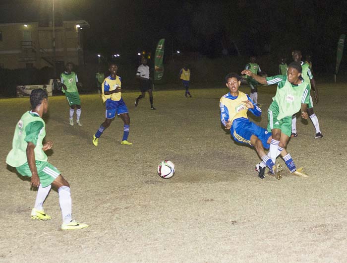 Players from Chase academic Foundation (green bibs) and South Ruimveldt battle for possession of the ball in their clash yesterday.