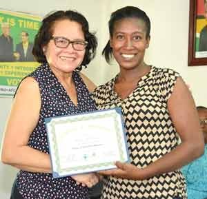 First lady, Mrs. Sandra Granger presents a certificate of completion to one of the recipients of the Self Reliance and Success in Business workshop held for Region Five women.