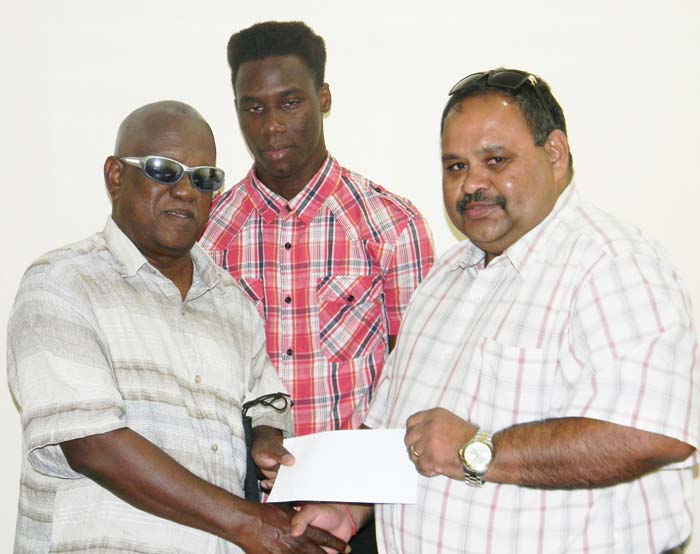 President of the GCB, Drubahadur (right) presents the donation to Executive Member of GuyBCA, Cecil Morris.