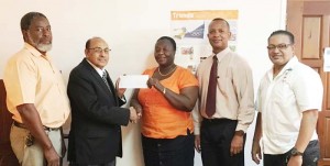 President of the GOA, Mr. Kalam Juman-Yassin makes the presentation to Ms. Sheryl Hermonstine of the Athletic Association of Guyana of 2-Airline Tickets for the Carifta Games to be held in Grenada in the presence of (from left) GOA Secretary Hector Edwards, President of the AAG Aubrey Hutson and GOA Council Member Gokarn Ramdhani.