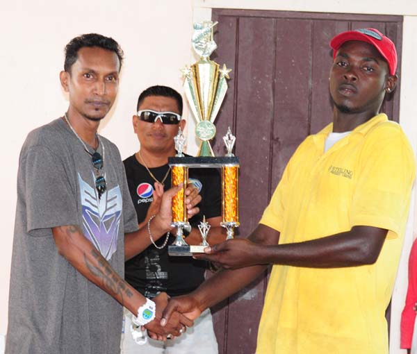 Captain of the Sans Souci team Seon Venture (right) accepts the trophy from WCC chairman Keval Persaud. 