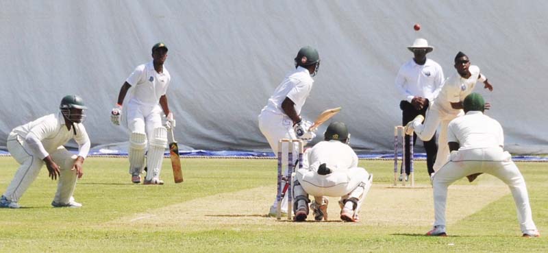 Umpire Shannon Crawford watches as Damion Jacobs bowls to Rajendra Chandrika.