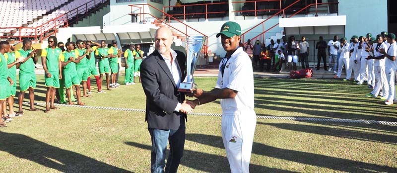 WICB’s Director of cricket Richard Pybus presents Jaguars Captain Leon Johnson with the winning trophy on Sunday at Providence.