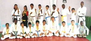 Some of the outstanding participants of the Guyana Mixed Martial Arts Karate Association along with Master Lloyd Ramnarine (standing right) display their medals.