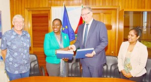 EU Ambassador Jernej Videtiè presents copies of the terms of reference to Minister Nicolette Henry in the presence of Ben ter Welle and Nirvana Persaud.