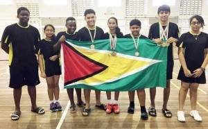 The successful Badminton team proudly flies the Golden Arrowhead as they display their medals after a productive outing in Suriname over the weekend.