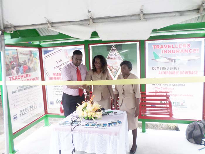 Assuria General Manager Yogindra Arjune & Deputy Town Clerk Sharon Harry-Munroe cut the ribbon while Debra Lewis, also of M&CC, looks on.