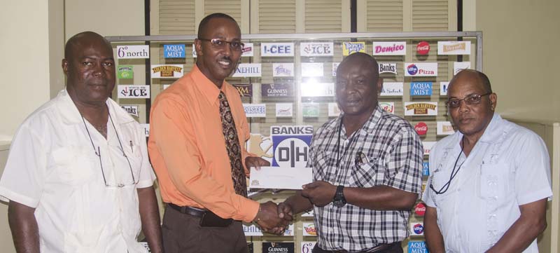 Banks DIH Limited PRO Troy Peters (2nd right) presents the cheque to GuyanaNRA Secretary Ryan Sampson. At right is association Treasurer Terrance Stuart with Caribbean Individual Champion Lennox Braithwaite also sharing the moment.
