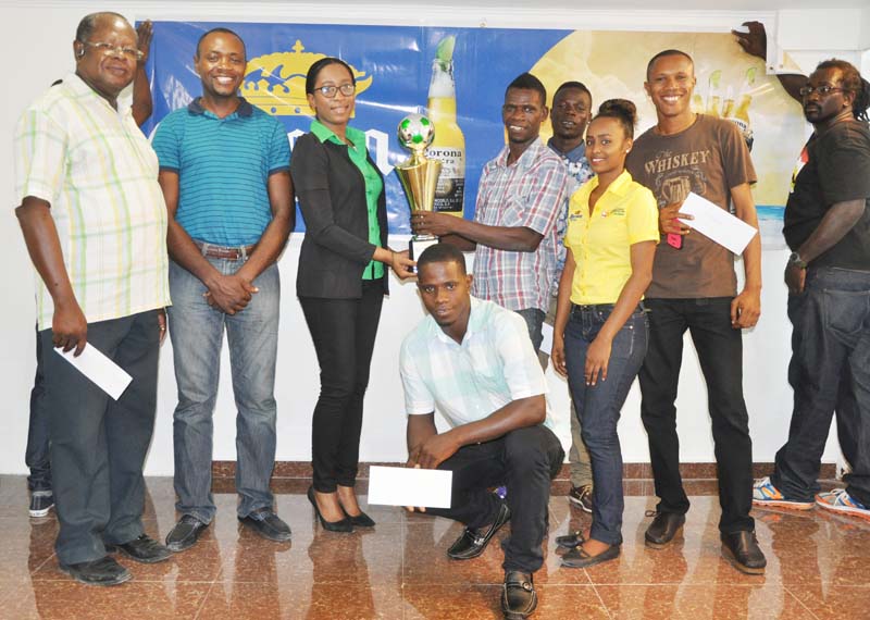 Top Brandz Marketing Rep. Ms Lise Lewis presents the winning trophy to Michael Baird of Royal Youths in the presence of other recipients of prizes. Top Brandz Marketing Team Member Ms Shontel Browne is 2nd right. 