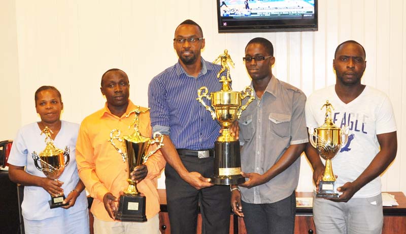  Captain of the victorious Pourderoyen FC Jermaine Mc Donald accepts the first place trophy from DOS Christopher Jones in the presence of Orville Bobb (2nd left) coach of Uitvlugt FC, Kerron Schmidt (right)  and Denneze Lovell (left). 