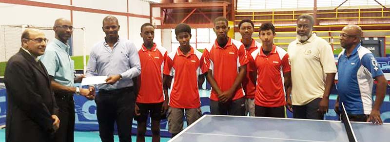 GOA Treasurer, Garfield Wiltshire (second, left) and President, K.A. Juman Yassin (left) hand over the sponsorship cheque to GTTA President, Godfrey Munroe in the presence of the National Junior Boys’ team and coach, Linden Johnson (right).