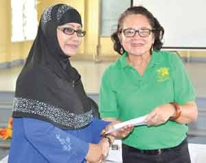 First Lady, Mrs. Sandra Granger presenting Ms. Latchmin Azeez with a letter a approval for a grant for the Bushlot-Armadale Women’s Group.