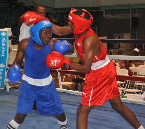 Quincy Boyce (left) in an exchange with Jerome Ennis of Jamaica.  Boyce surrendered his 64kgs bout to the Jamaican.