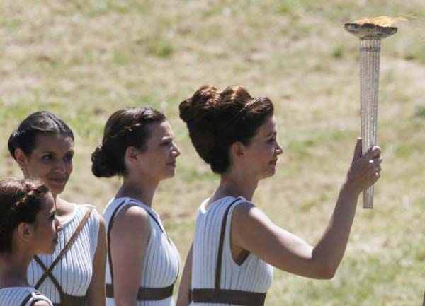 Greek actress Katerina Lehou (R), playing the role of High Priestess, holds the Olympic flame during the Olympic flame lighting ceremony for the Rio 2016 Olympic Games inside the ancient Olympic Stadium on the site of ancient Olympia, Greece, yesterday. Reuters/Yannis Behrakis