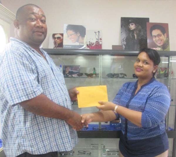 Len’s Craft Supervisor Tayasha Kanhai hands over donation to Hilbert Foster.