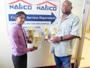Club Secretary/CEO Hilbert Foster (right) receives  donation from a representative of Nalico.