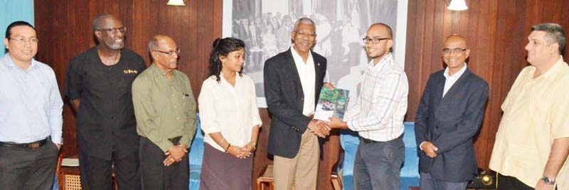 PAC Commissioner, Mr. Damian Fernandes presents President David Granger with a document the Commission compiled, while the other commissioners look on.