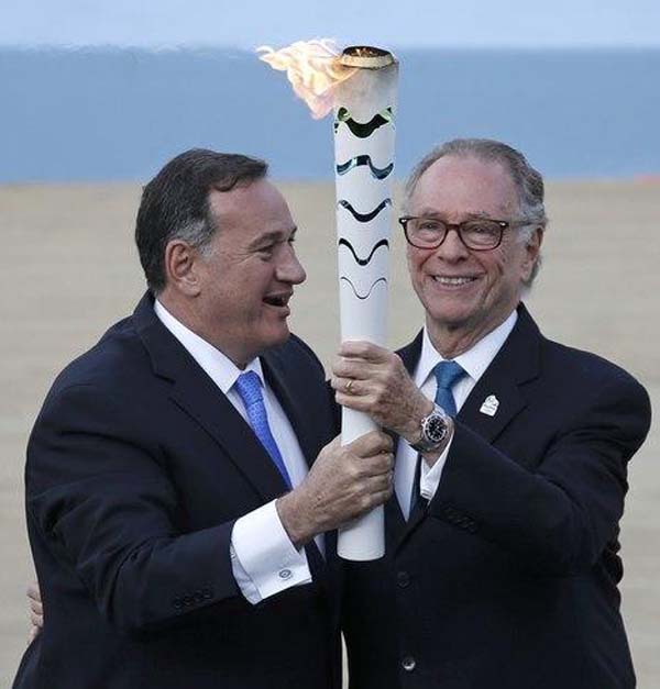Spyros Capralos, head of the Hellenic Olympic Committee (L), hands over an Olympic torch to Rio’s Olympic chief Carlos Nuzman during the handover ceremony of the Olympic Flame to the delegation of the 2016 Rio Olympics, at the Panathenaic Stadium in Athens, Greece, April 27, 2016. (REUTERS/Alkis Konstantinidis)
