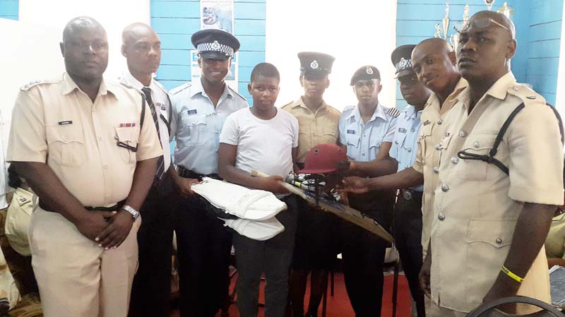  Superintendent Lindon Hyles (right), Deputy Superintendent Marlon Taylor (Left),  Deputy Superintendent Guy Nurse and Inspector La Rose, King and his mother at centre and other ranks share the moment. 