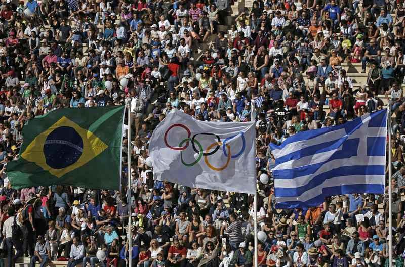 The Brazilian, Olympic and Greek flags fly over the Panathenaic Stadium during the handover ceremony of the Olympic Flame to the delegation of the 2016 Rio Olympics, in Athens, Greece, April 27, 2016.  (REUTERS/Alkis Konstantinidis)