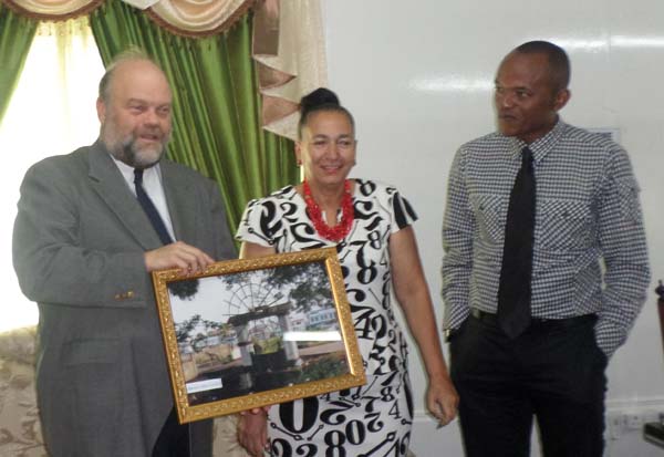 US Ambassador Halloway presents gift to Mayor Chase-Green while Deputy Mayor Duncan looks on.