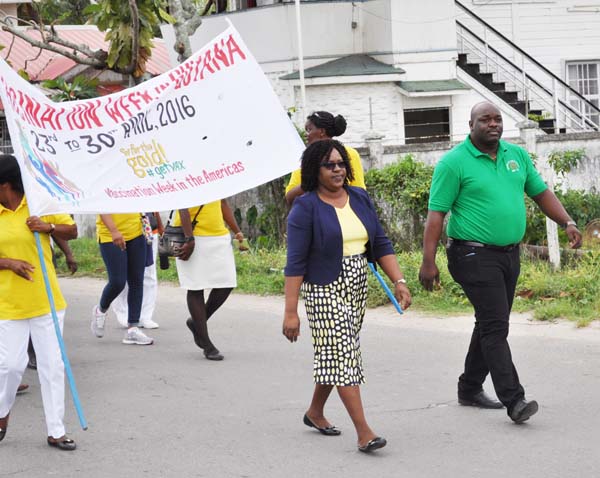 Minister Karen Cummings and Mr Jevon Stevens lead the Vaccination Week march.
