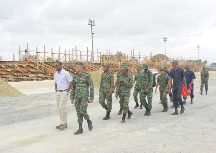 Head of the Ministry of Public Infrastructure’s Special Projects Unit, Lawrence Mentis (front, left) in discussion with Guyana Defence Force Captain, Daniel Seeram, and some troops.