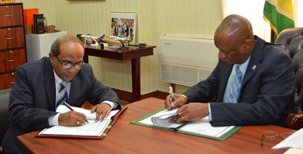 Indian High Commissioner to Guyana, Venkatachalam Mahalingam (left), and Minister of State, Joseph Harmon signing the Memorandum of Understanding.