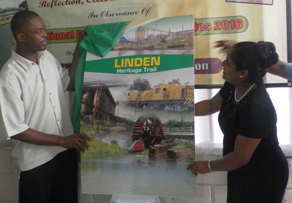  Linden Mayor Carwyn Holland unveils the cover of the Linden Heritage Trail with the help of National Trust CEO Nirvana Persaud