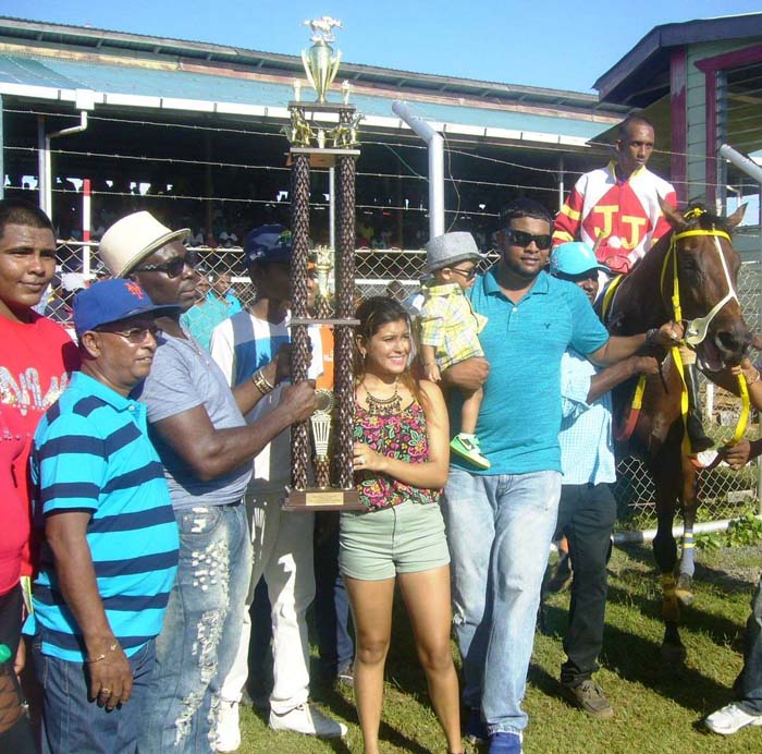 Aubrey Elcock presents the beautiful trophy in the D, E and F class race for Release the Beast win to Mrs Nazrudeen (Jumbo Jet) Mohammed jr.