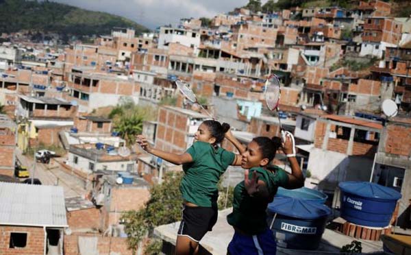 Brazilian badminton players Lohaynny Vicente (L), 20, and her sister Luana Vicente, 22, pose for a photograph on the roof of a house in Chacrinha favela in Rio de Janeiro, Brazil, May 4, 2016. (REUTERS/NACHO DOCE)