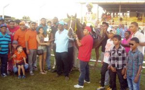Director Of Sport Christopher Jones presents the 50th Anniversary trophy to connections of The Jumbo Jet stable for Kings Knight victory in the feature event.