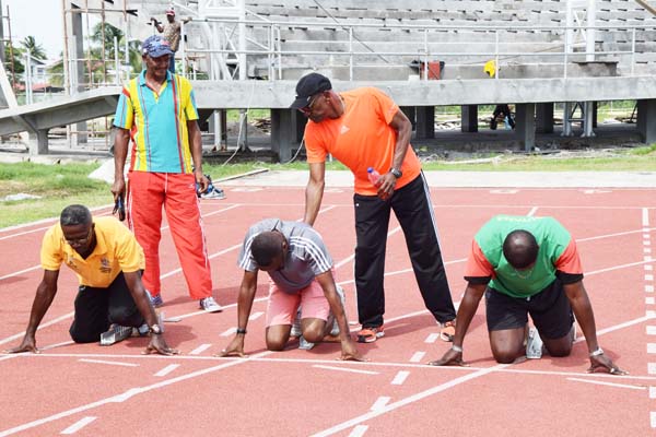 IAF accredited Level 1 Coah Kenrick Smith (standing right) demonstrates to one of the participants the right position to be in the blocks during the Clinic which was held on Sunday at Leonora Synthetic Track facility.