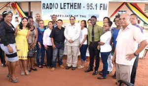 Prime Minister Moses Nagamootoo (centre) and Project Coordinator Dr. Rovin Deodat (extreme right) pose with young volunteer broadcasters after the official opening of Radio Lethem