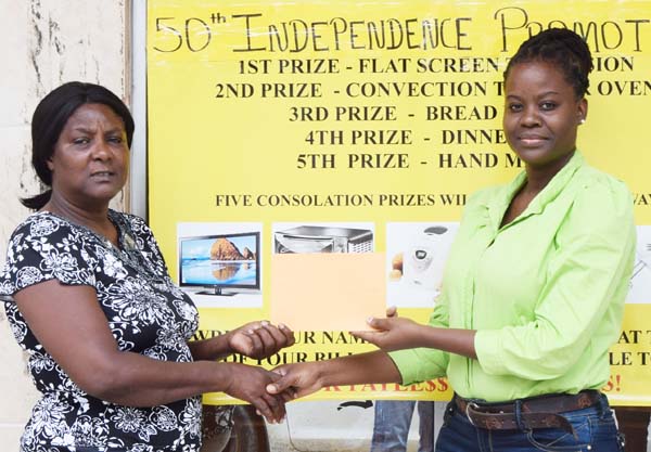 Manager of Payless Variety Store Shonel Benjamin (right) hands over a cheque for an undisclosed sum to Organising Committee member Avril Black yesterday.