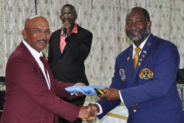 President of the Antigua and Barbuda Shooting Club, Thomas Greenaway (right) hands over the WIFBSC Flag to GuyanaNRA Captain Mahendra Persaud.