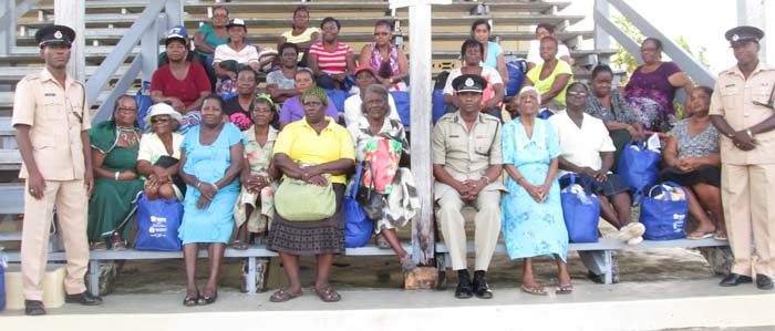  The mothers that were honoured along with Police officers of the area and other officials share a photo following the presentation of hampers. 