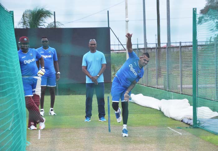 Sunil Narine is watched by Umpire Greg Braithwaite, Sulieman Benn and non-striker Kieron Pollard as he bowls during yesterday practice session at Providence.