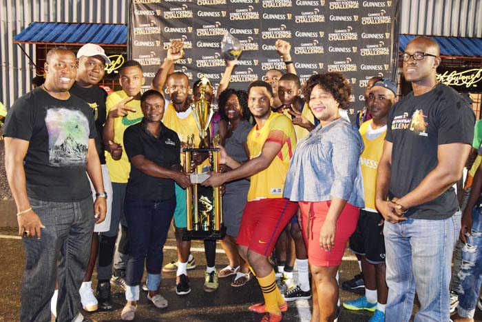 Captain of Team 25 Ryan Noel receiving the Championship trophy from Linden Manager Shondel Easton in the presence of teammates, Guinness Brand Manager Lee Baptiste and Outdoor and Events Manager Mortimer Stewart.