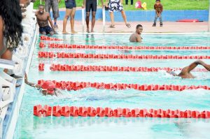 Trumaine Cole (left) of Silver Sharks powers to the finish line ahead of GPF’s Deon Primus in the 100M Free. (Franklin Wilson photo)