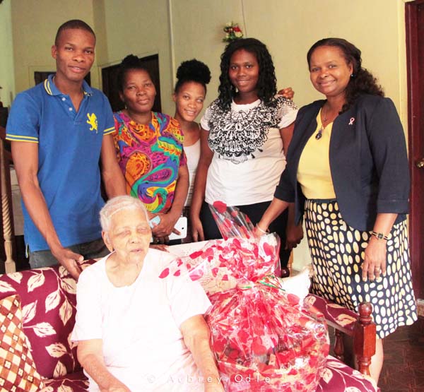 Centenarian Agnes Benjamin is joined for a photo opportunity by her relatives and Minister of Social Protection, Volda Lawrence (right)