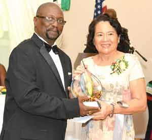 First Lady Mrs. Sandra Granger receiving her award from President of the GAC, Mr. Errol Lewis 