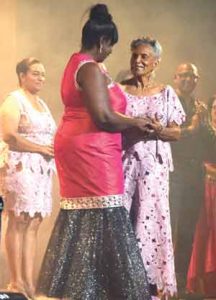 Winner of the 1990 pageant Mrs. Eileen Barker was presented with a special award by Mrs. Ingrid Fung .